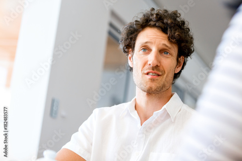 Portrait of man sitting and talking to woman indoors