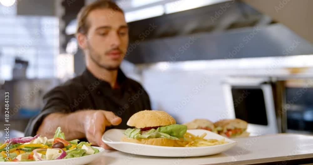 Chef keeping plates of burger on the order station Chef keeping plates of burger on the order station