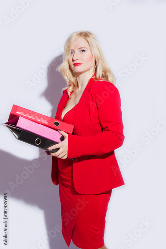 Portrait of a beautiful young blonde woman in a red business suit. The girl holds a folder for documents photo