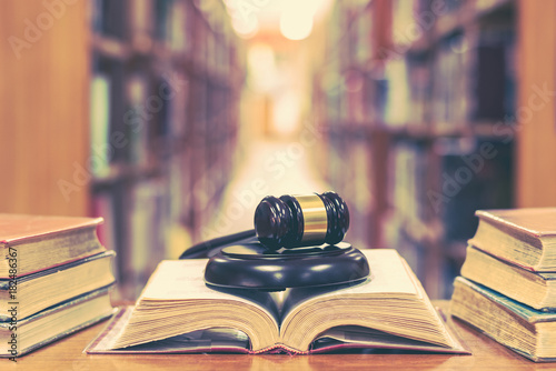 Old book in library with judge gavel on open law textbook in court archive text collection study room for copyrights day and international legal rights concept