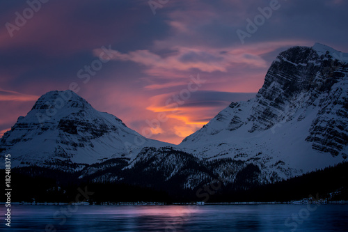 Foto Orange skies above a lake surrounded by mountains