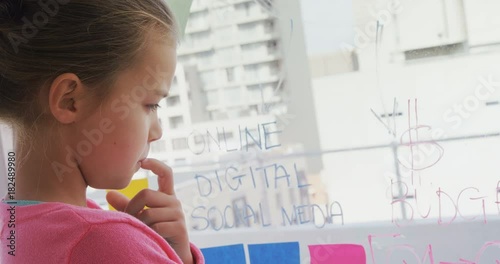 Thoughtful girl as executive reading the text on the wall  