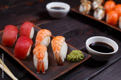 Nigiri sushi set with tuna and prawns served on clay plates, close up. Delicious traditional Japanese food, tasty seafood, sushi restaurant concept