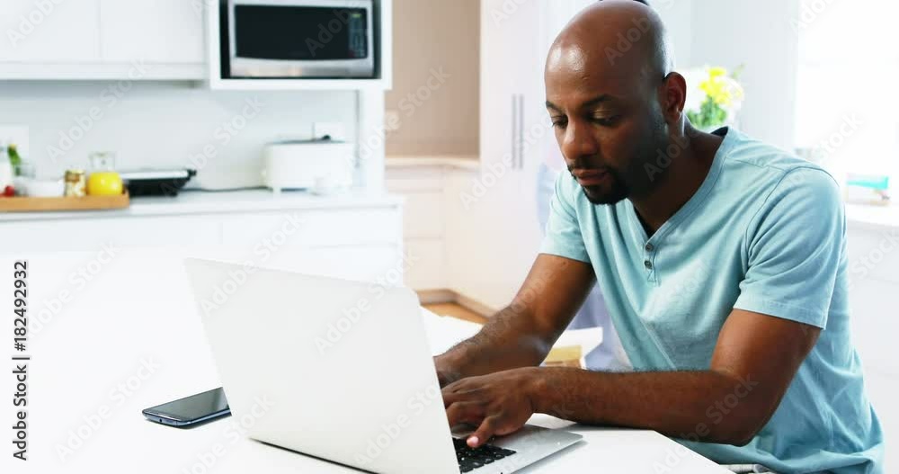 Man using laptop while woman talking on mobile phone Man using laptop while woman talking on mobile phone