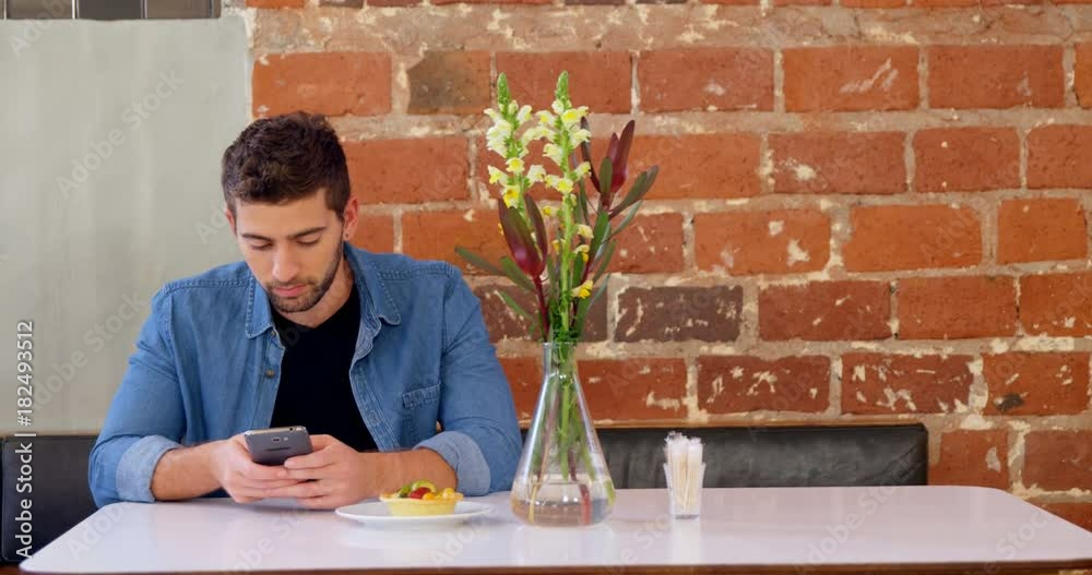 Handsome man using mobile phone at table Handsome man using mobile phone at table