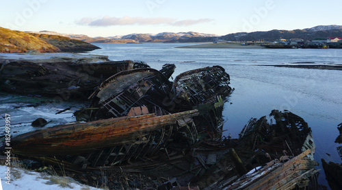 wrecked fisherman ship on the coast with mountain background in Teriberka