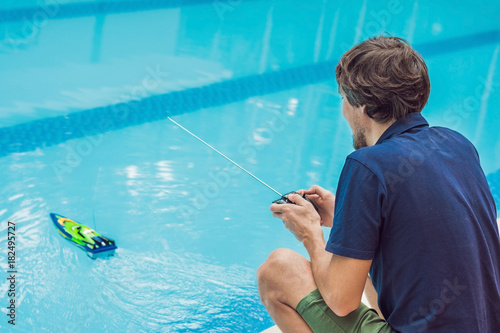 Man playing with a remote controlled boat in the pool photo