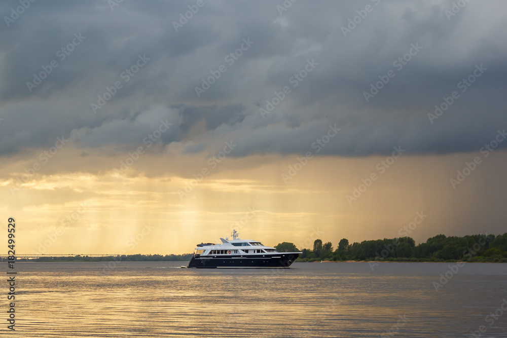 Naklejka premium Yacht against the background of a sunset on the river