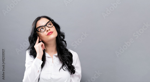 Young businesswoman in a thoughtful pose on a solid background