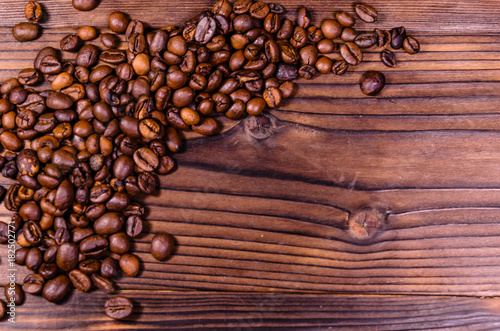 Pile of the roasted coffee beans on wooden table. Top view