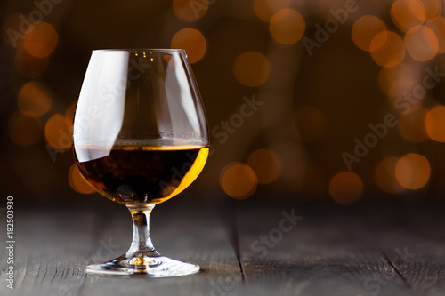 Glass of cognac on wooden table