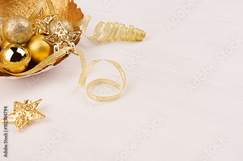 Christmas decorations of gold on white wood background, closeup.
