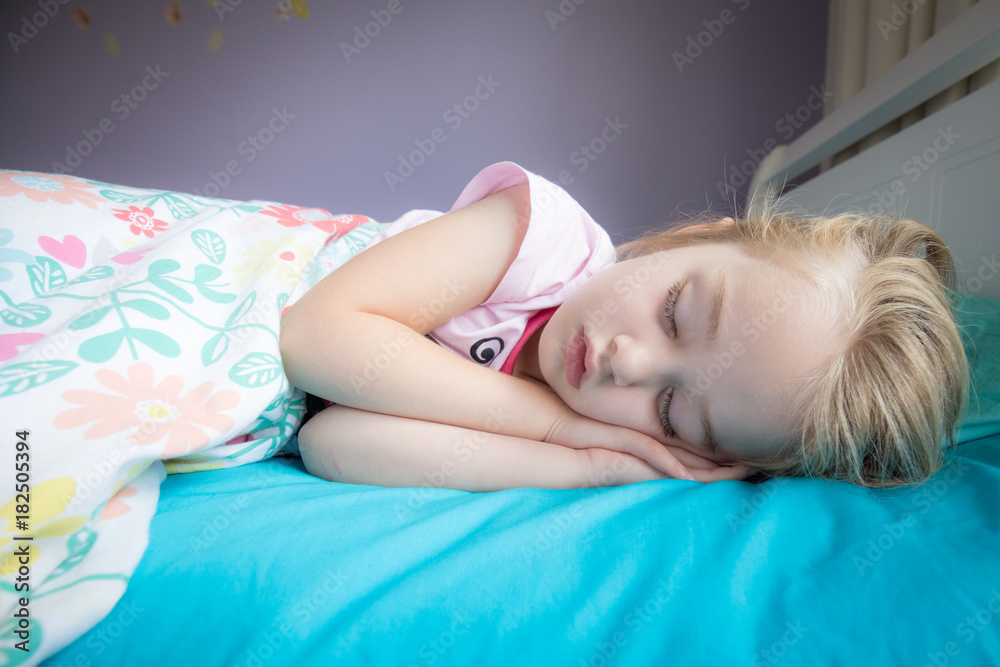 Naklejka premium little girl sleeping in her bed