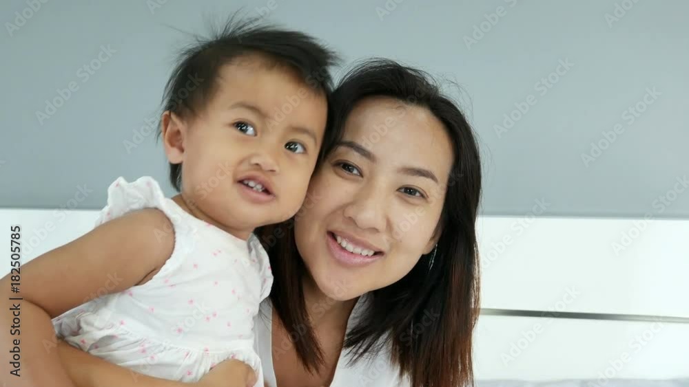 4k of Asian mom and her baby having fun and playing in white bed 4k of Asian mom and her baby having fun and playing in white bed
