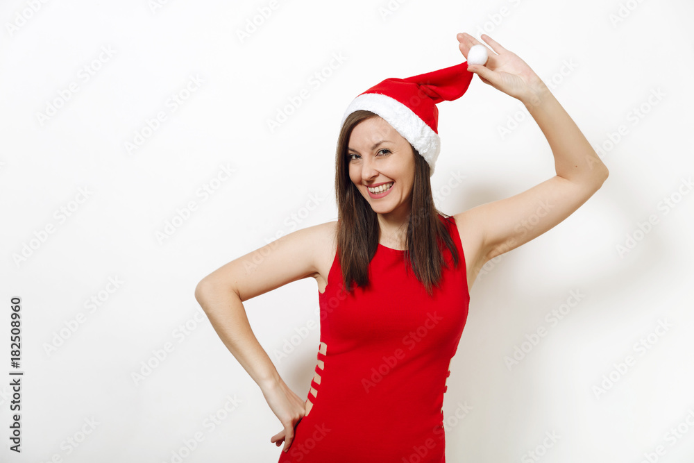 Beautiful caucasian young happy woman with healthy skin and charming smile wearing red dress holding Christmas hat on white background. Santa girl isolated portrait. New Year holiday 2018 concept Beautiful caucasian young happy woman with healthy skin and charming smile wearing red dress holding Christmas hat on white background. Santa girl isolated portrait. New Year holiday 2018 concept