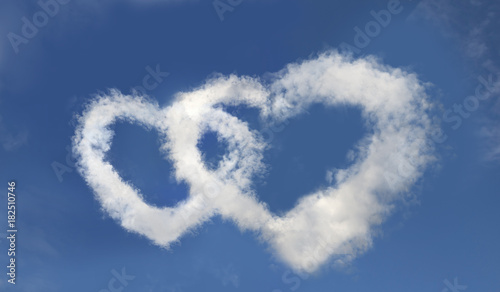 Two hearts made of clouds in the clear blue sky