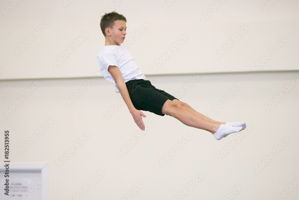 the young man performs gymnastic exercises in the gym. the young man performs gymnastic exercises in the gym.