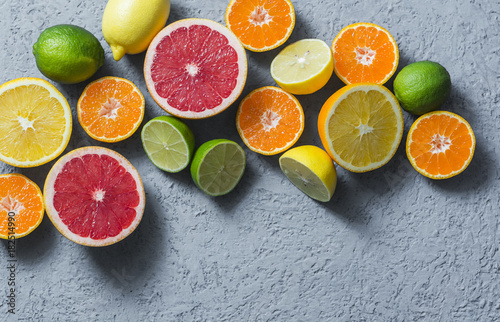 Assortment of citrus fruits on a grey background  top view. Oranges  grapefruit  tangerine  lime  lemon - organic fruits  vegetarian healthy food concept. Flat lay  copy space