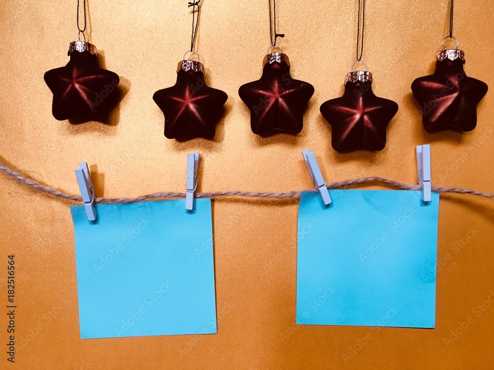 Blue blank memo papers on a golden background with Christmas decoration Blue blank memo papers on a golden background with Christmas decoration