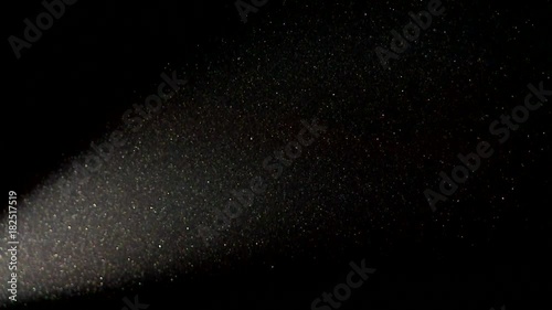 Particle of dust flies on a dark background in the light of a bright spotlight