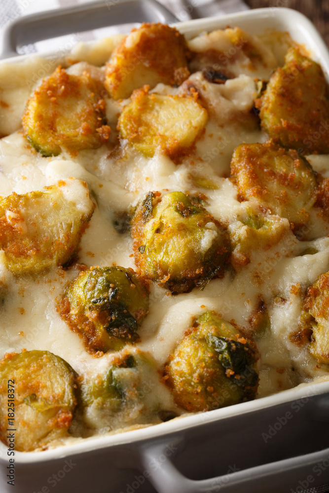 Casserole from Brussels sprouts with garlic and cheese sauce close-up. vertical Casserole from Brussels sprouts with garlic and cheese sauce close-up. vertical