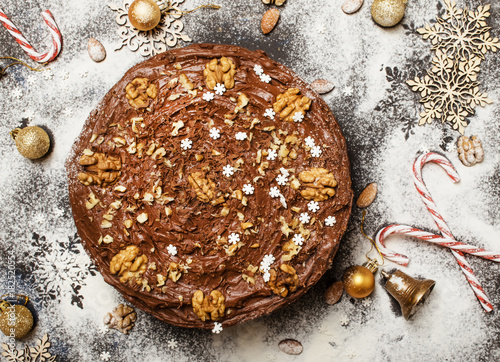 Photography Christmas chocolate cake with nuts, white snow background with new yaers decorat