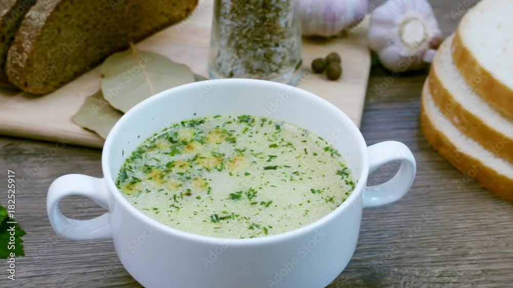 Mushroom soup with croutons in a white dish is on a wooden table. Tripod pan filming. Mushroom soup with croutons in a white dish is on a wooden table. Tripod pan filming.