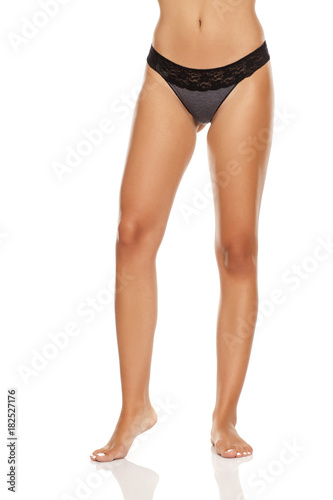 pretty, nice groomed woman's legs in black panties on white background