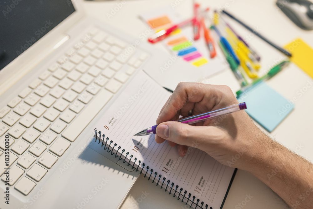 Close-up Of A Businessperson's Hand Writing Schedule In Diary With Pen Close-up Of A Businessperson's Hand Writing Schedule In Diary With Pen