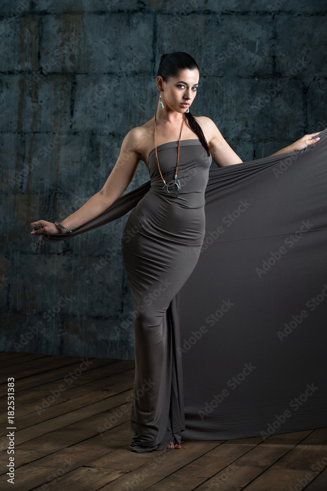 fashion studio portrait of sensual woman with dark hair and bright makeup with bijou