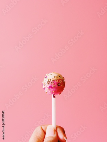 Tela Close up lollipop with golden glitter on pink background.