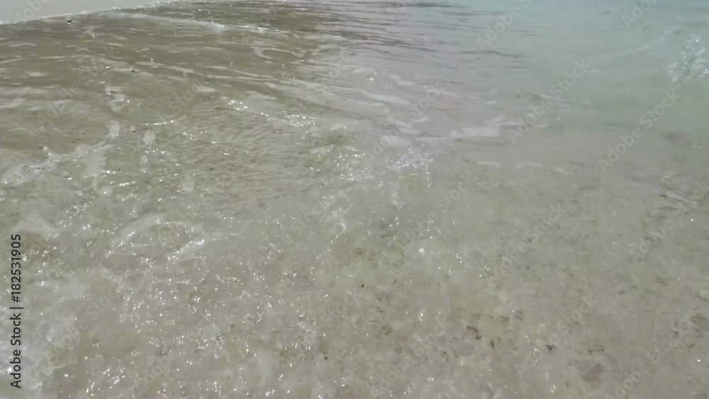 Soft waves of blue ocean on sandy beach. Gentle waves rolling on a tropical beach. Soft waves of blue ocean on sandy beach. Gentle waves rolling on a tropical beach.
