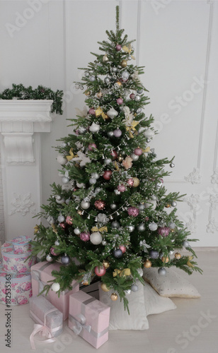 Christmas tree with presents underneath in living room. Delicate tones and festive mood. Close-up. © Nick Vakhrushev