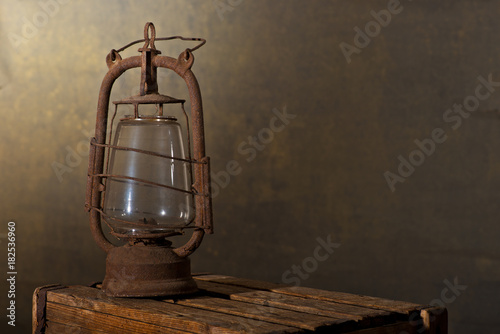 Old Rusty Lantern on the Wooden Desk in the Attic