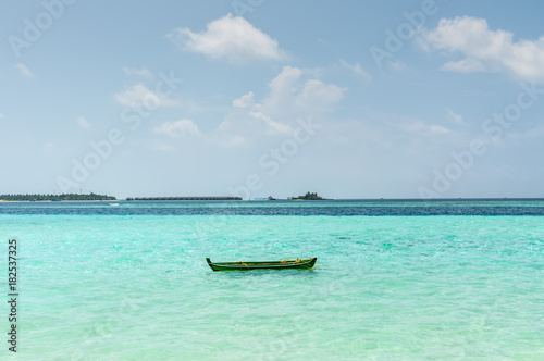 Fototapeta Naklejka Na Ścianę i Meble -  Small boat and bungalow on the horizon on Maldives - nature travel background - exotic beautiful marine beach of Gulhi island