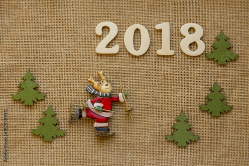 2018 Elch auf Schlittschuhen verkleidet als Weihnachtsmann mit Tannenbäumen auf Jute