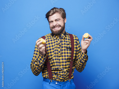 Disgusted man tasting sour a lemon photo
