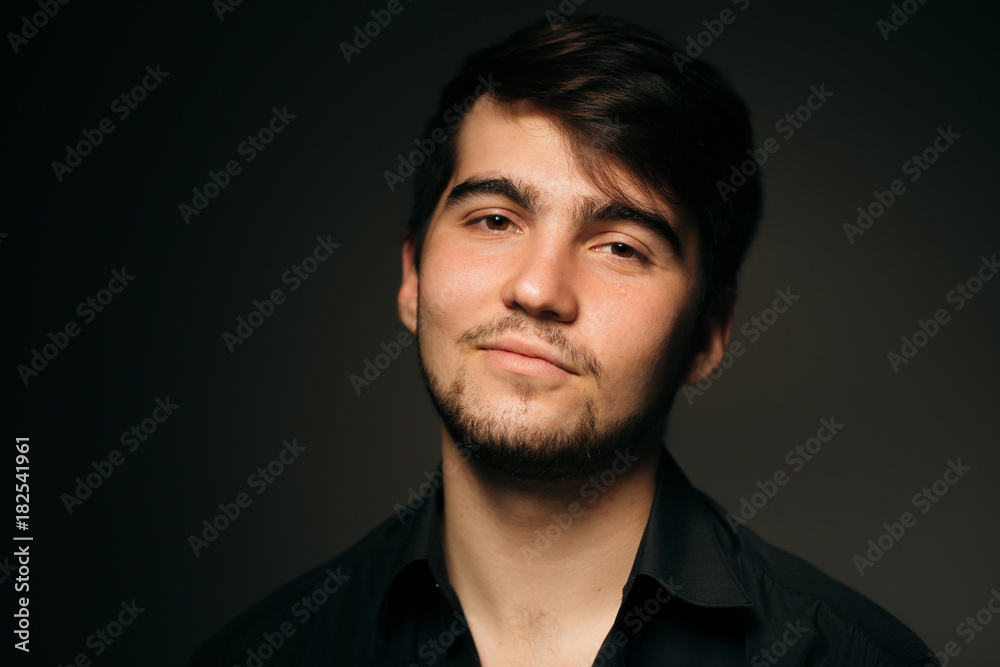 young brunette guy on a dark background young brunette guy on a dark background