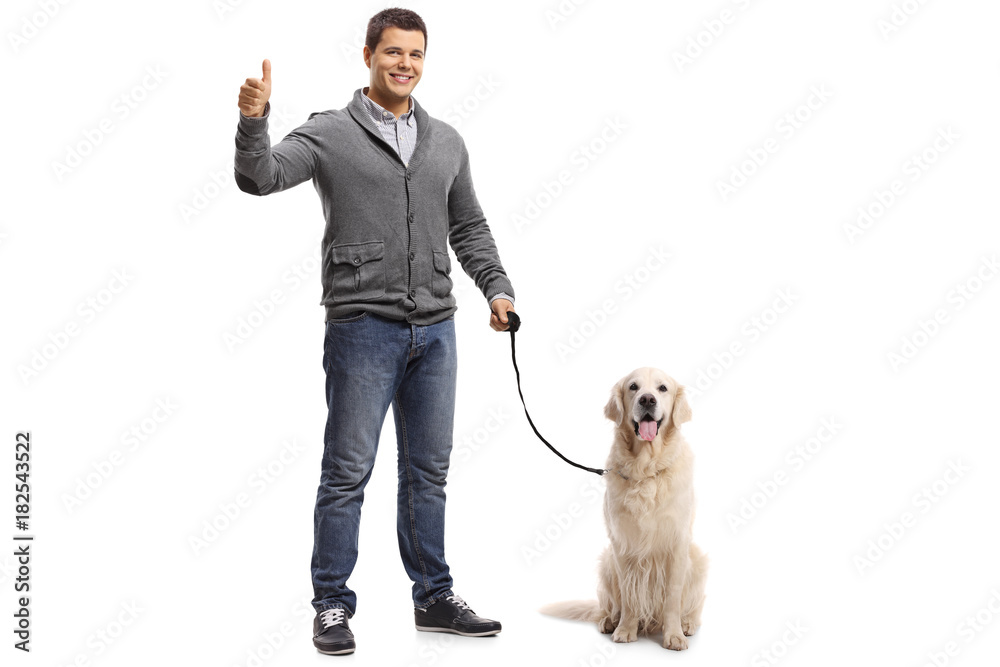 Young man with a labrador retriever making a thumb up gesture Young man with a labrador retriever making a thumb up gesture