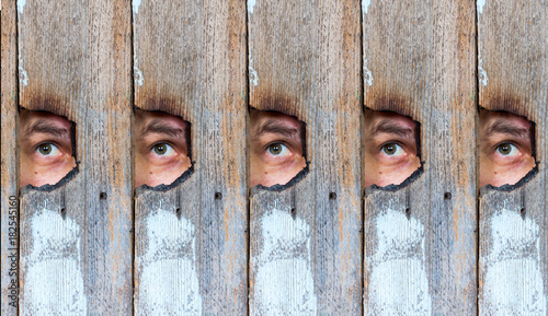 Photos abstract collage of the human eye, voyeur spying through a hole in the old woode