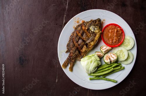 Indonesian dish ikan goreng (fried fish) with copy space left.