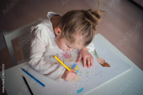 cute little girl draws with crayons