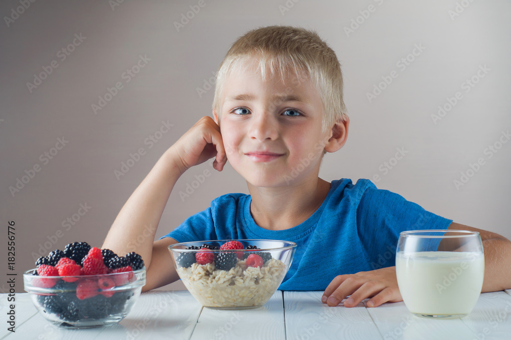 Little boy is eating oatmeal with berries. Little boy is eating oatmeal with berries.