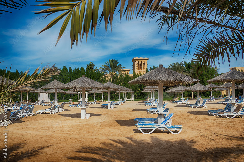 The beach in Ras Al Khaimah with umbrellas and sunbeds.