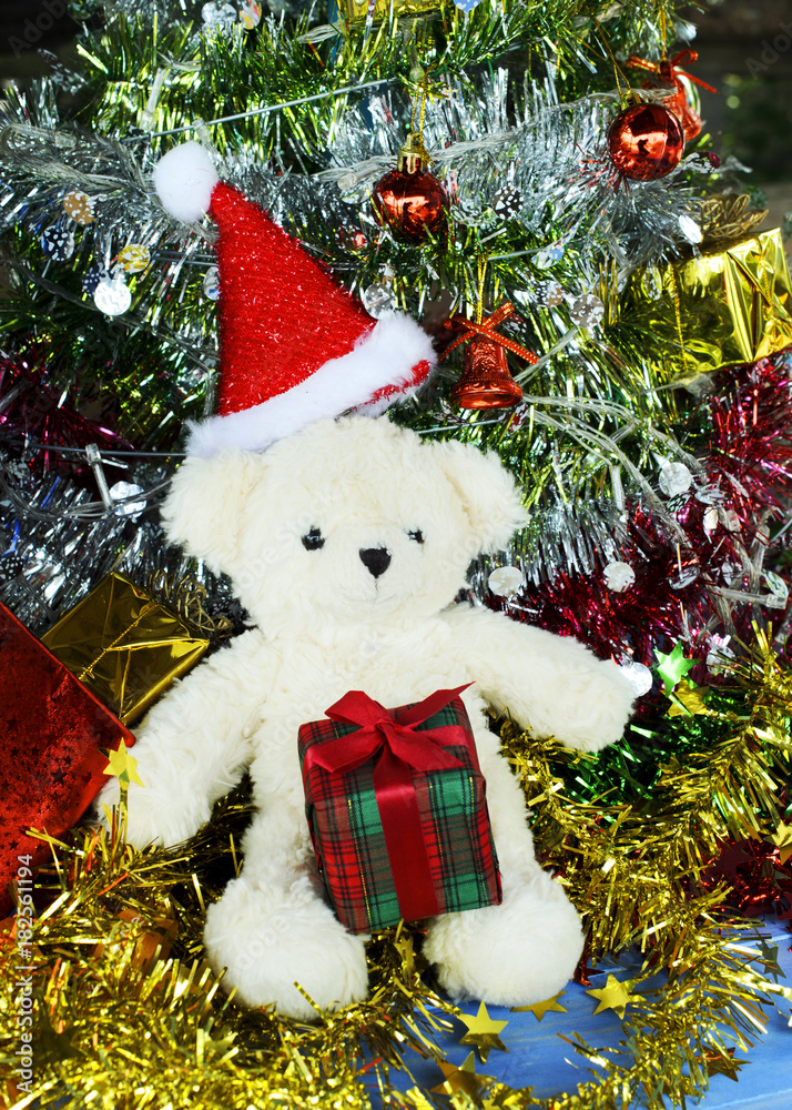 Teddy bear with santa hat and gift box for Christmas holiday backgrounds concept Teddy bear with santa hat and gift box for Christmas holiday backgrounds concept