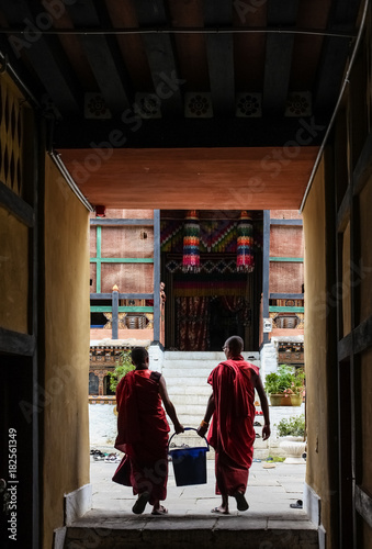 Punakha, Bhutan - September 11, 2016: Two Bhutanese monks carrying a bucket in Chimi Lhakhang (Monastery of Fertility), Bhutan