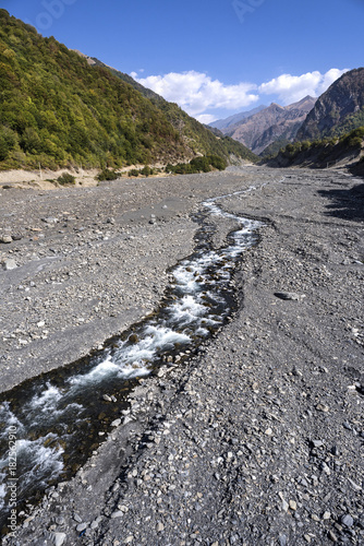 Azerbaijan, Greater Caucasus, near Qabala, Durja and Laza: Huge rocky river bed with streams, floating water and mountain chain. photo