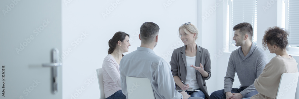 Therapist talking to people - obrazy, fototapety, plakaty 