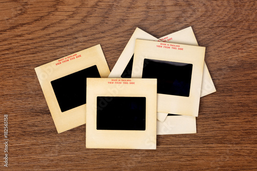 Vintage 35-mm mounted film slides on wooden background