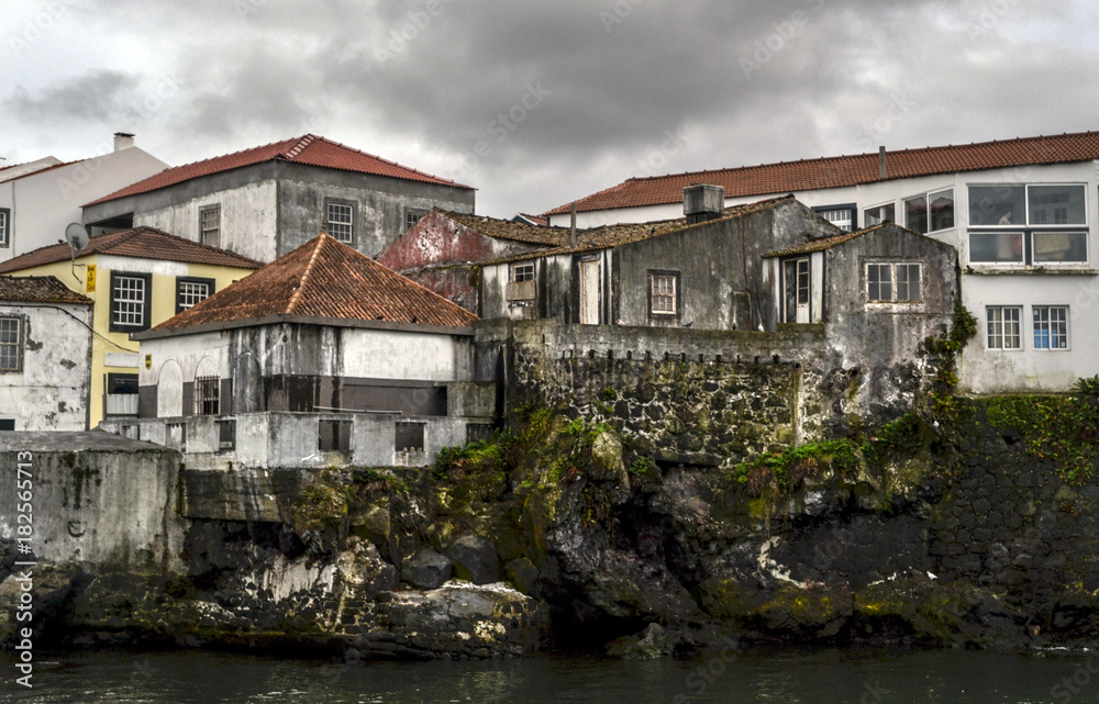 old houses on rocks with red roofs in the port of the island of Pico in the Azores
